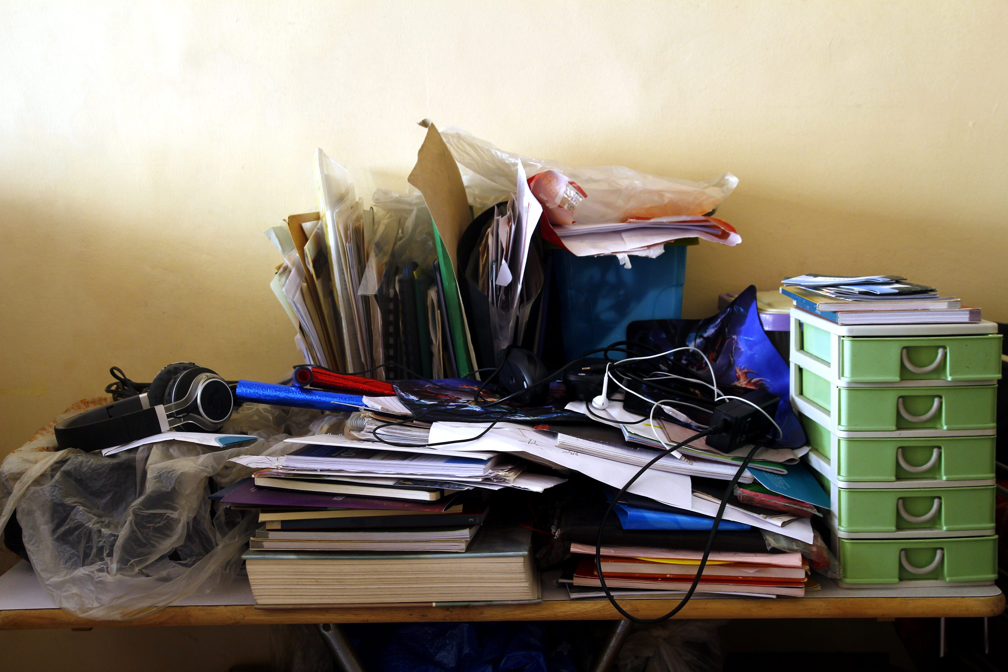 Photo of messy and cluttered work table with lots of paper and books