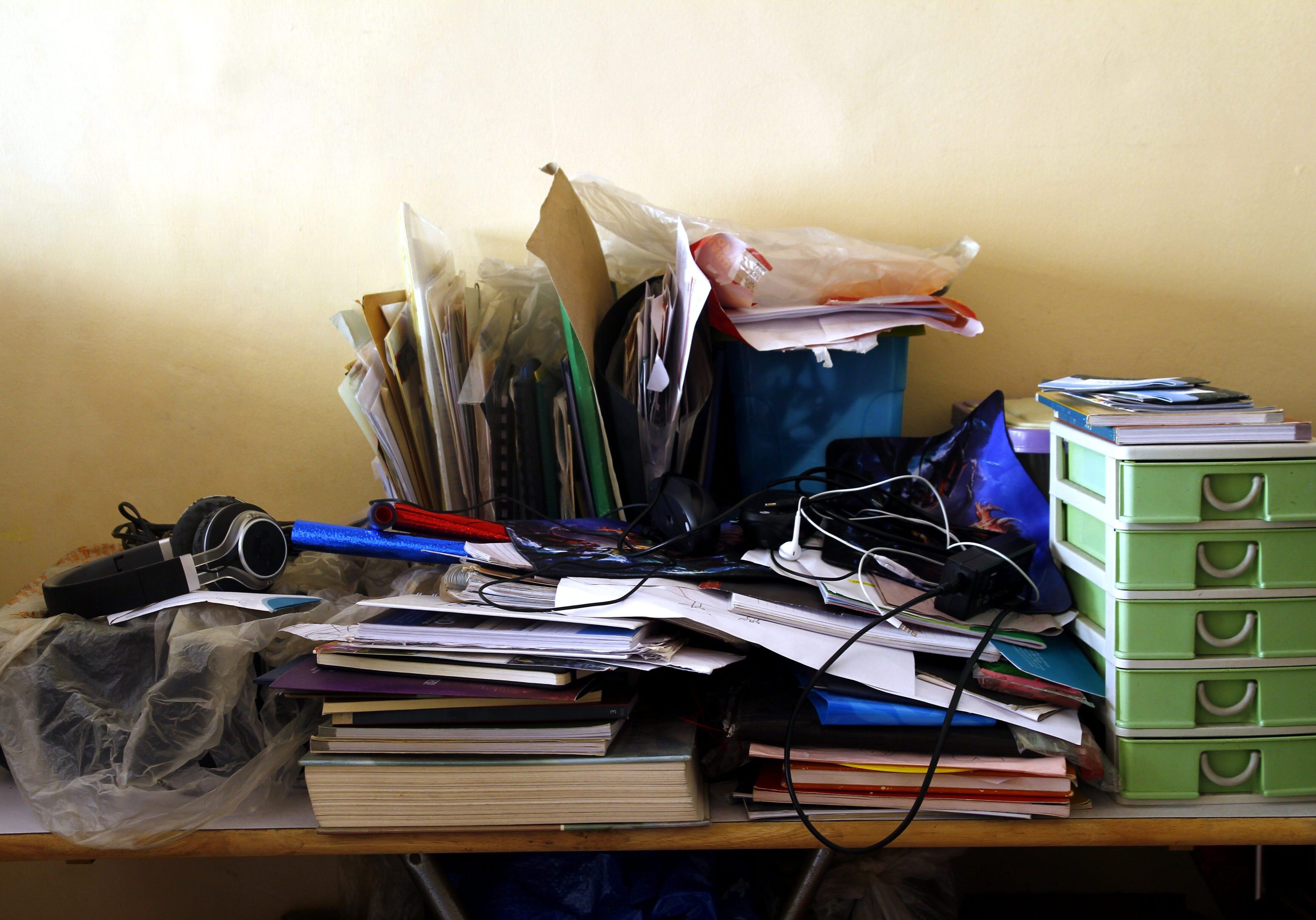 Photo of messy and cluttered work table with lots of paper and books